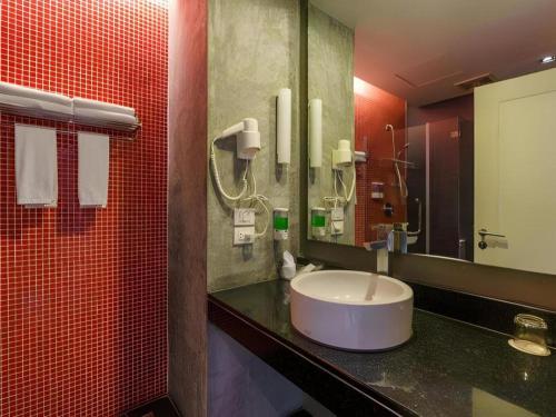 a bathroom with a sink and a mirror at The Park Residence in Bangkok