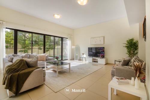 a living room with a couch and a table at Manzil - 4BR Villa in Prime Location with Private Garden in Dubai