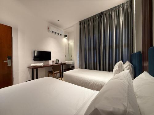 a hotel room with two beds and a desk at OYO 91193 Hi Inn Sibu Jaya in Sibu