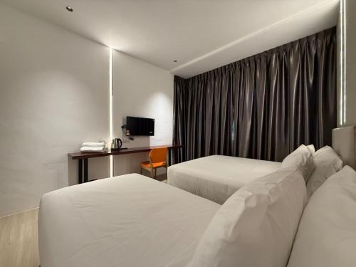a hotel room with two beds and a window at OYO 91193 Hi Inn Sibu Jaya in Sibu
