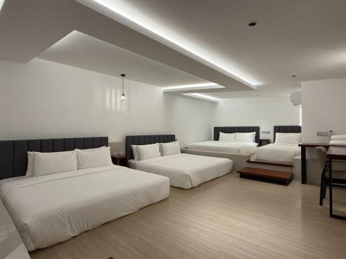 a hotel room with two beds and a desk at OYO 91193 Hi Inn Sibu Jaya in Sibu