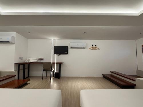 a room with a bed and a table and a desk at OYO 91193 Hi Inn Sibu Jaya in Sibu