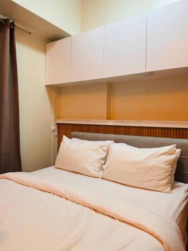 a bedroom with a bed with white pillows at Stylish Bright Stay for Work or Leisure in Molo