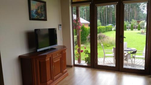 a living room with a tv and a sliding glass door at Holiday Home Medus in Babīte