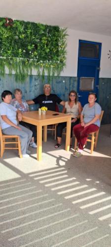a group of people sitting around a wooden table at Valahia in Dunavăţu de Jos