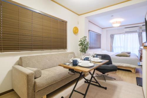 a living room with a couch and a table at Cozy Nest Sangenjaya 1 Stop to Shibuya ーWalk to Sangenjaya and Ikejiri in Tokyo