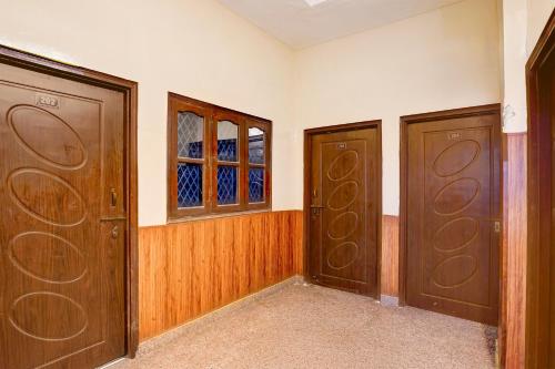 a room with two wooden doors and a window at Hotel O Dehradun City Centre in Dehradun