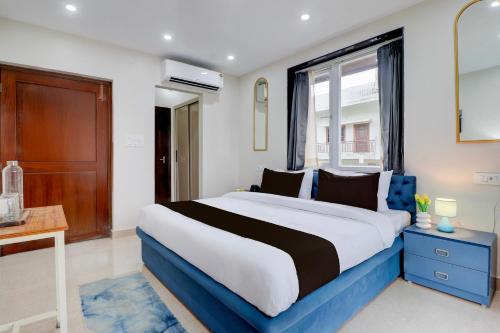 a bedroom with a large bed and a window at Super Townhouse Rispana River Dehradun Formerly Nivasa Home Stays in Dehradun