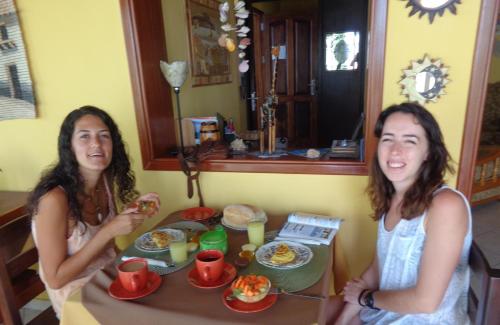two women sitting at a table eating food at Casa Comba in Mindelo