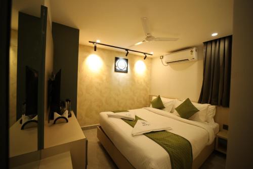 a bedroom with a bed and a clock on the wall at Hotel Bilton Wilson Garden Near Nimhans Hospital in Bengaluru