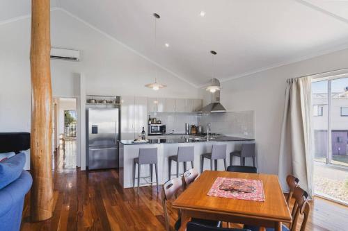 a kitchen and living room with a table and a counter at Peppy Harmony House - Coastal Calm on Geographe Bay in Capel