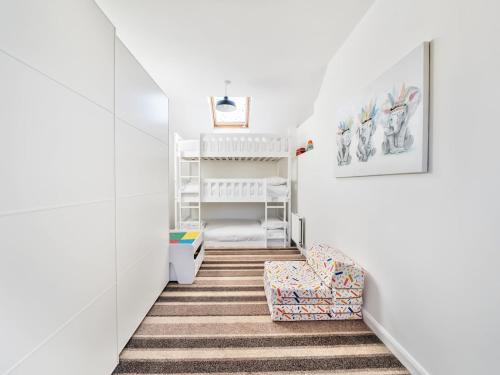 a room with white walls and a staircase with a chair at Pass the Keys Large Family Home Parking - Oxford in Oxford