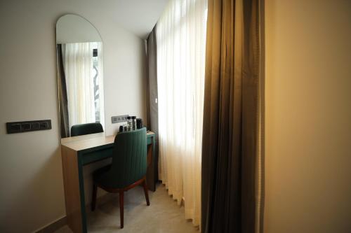 a room with a desk and a mirror and a chair at Hotel Bilton Wilson Garden Near Nimhans Hospital in Bengaluru