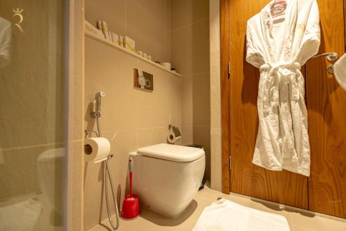 a bathroom with a white toilet and a shower at Stylish Pearl 1BR - Chic Julphar Getaway in Abu Dhabi