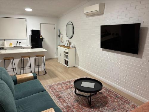 a living room with a couch and a tv on a wall at Cosy Perth retreat in Perth