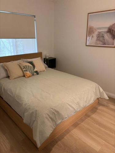 a bed in a bedroom with a large window at Cosy Perth retreat in Perth