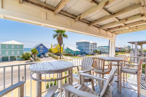 a balcony with tables and chairs and a view of the ocean at Laguna Bella C4 in Gulf Shores