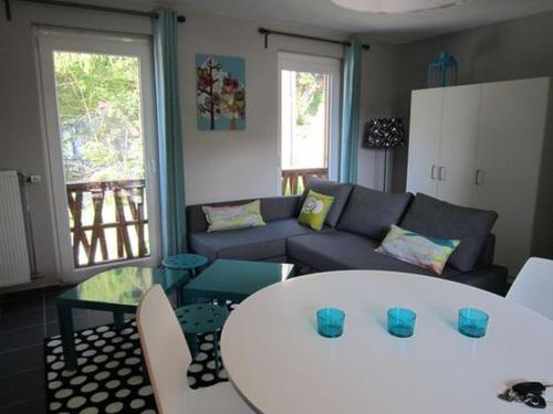 a living room with a white table and a couch at Studio Le Vedeur in Durbuy