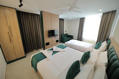 a hotel room with two beds and a television at Hotel Bilton Wilson Garden Near Nimhans Hospital in Bengaluru