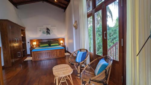 a bedroom with a bed and a table and chairs at Lagoon gate Tangalle Resort in Tangalle