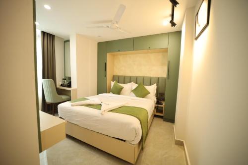 a bedroom with a bed with a green wall at Hotel Bilton Wilson Garden Near Nimhans Hospital in Bengaluru