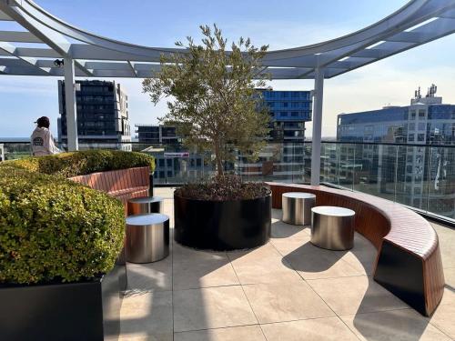 a balcony with benches and a tree on a building at Grand Bayview Corporate Residency in Melbourne