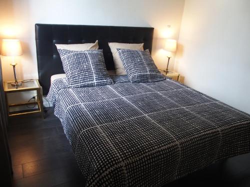 - un lit avec une couverture et des oreillers en damier noir et blanc dans l'établissement Bed and Breakfast Le patio, à Montigny-lès-Metz