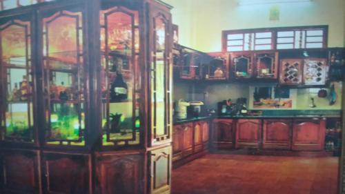 uma cozinha com um armário de madeira com portas de vidro em Hoa Phuong Guesthouse em Ðông Hà