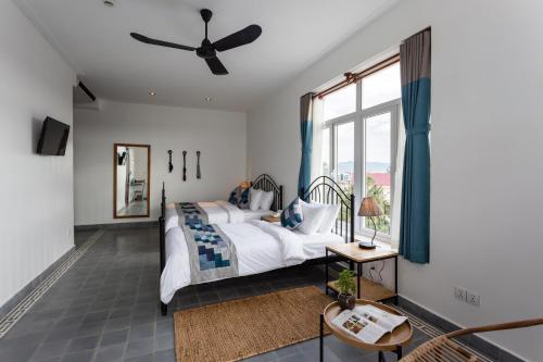 a bedroom with a bed and a ceiling fan at Boutique Kampot Hotel in Kampot