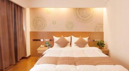 a bedroom with a large white bed with white pillows at GreenTree Inn Jinzhong PinGYAo City South Railway Station Express Hotel in Pingyao