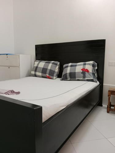 a large black bed with two pillows on it at Hidalgo Explorers Home in Moshi