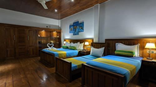 a bedroom with two beds with blue and yellow at Lagoon gate Tangalle Resort in Tangalle