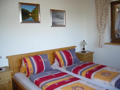 a bedroom with two beds and two pictures on the wall at Ferienwohnung Marlene in Alpbach