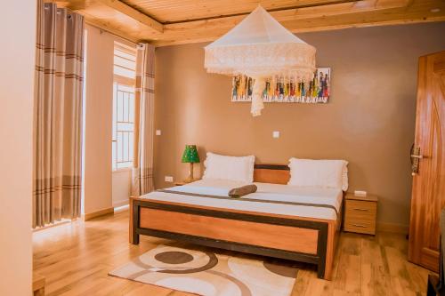 a bedroom with a bed and a chandelier at NANA Homestay NEAR AIRPORT in Kigali