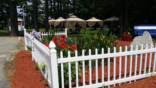 a white picket fence in a garden with flowers at Seabrook Inn in Seabrook