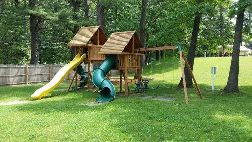 a playground with a house and a slide at Seabrook Inn in Seabrook