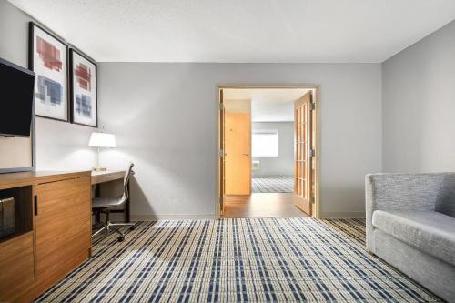 a hotel room with a desk and a chair at AmericInn by Wyndham Wausau in Weston