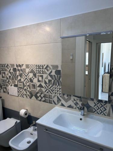 a bathroom with a sink and a toilet and a mirror at Soffio di mare in San Vincenzo