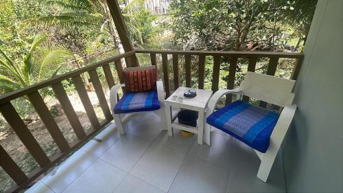 a balcony with two chairs and a table on a balcony at Canal hut 2 - Chaloklum in Chaloklum