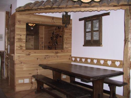 ブレウイル・チェルヴィナイアにあるクロモセラピー アパートメントの木製のテーブルとベンチが備わる木造の客室です。