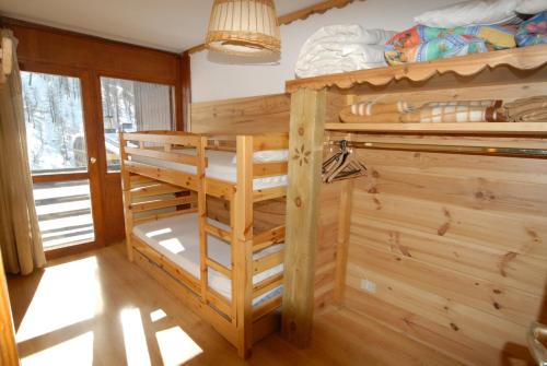 een slaapkamer met een stapelbed in een blokhut bij Cromotherapy Apartment in Breuil-Cervinia