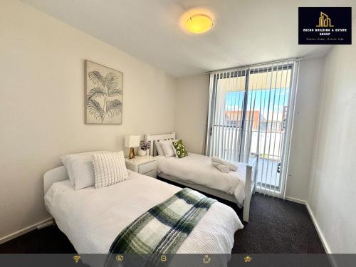 une petite chambre avec deux lits et une fenêtre dans l'établissement 3BR Apartment close to tram station, à Harrison