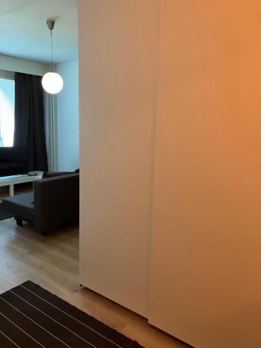 an orange wall in a living room with a couch at Yksiö Asemakadulla in Lapua