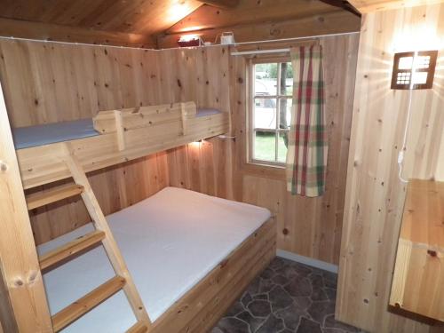 a bunk bed in a cabin with a window at Smegarden Camping in Oppdal
