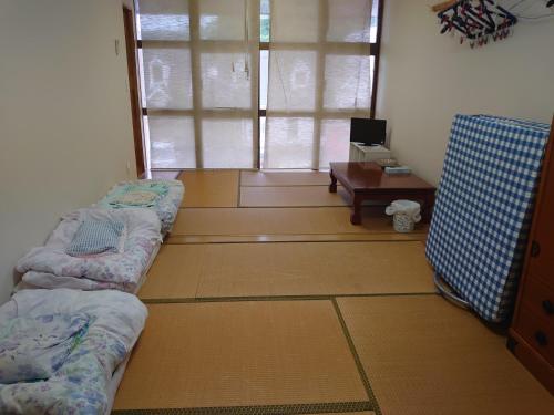 a room with two beds and a table and a window at 民宿たけだ家 in Saka