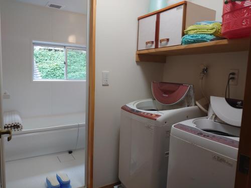 a bathroom with a sink and a washing machine at 民宿たけだ家 in Saka