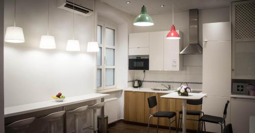 a kitchen with white cabinets and a table with chairs at B&B Cool Centre Zagreb in Zagreb