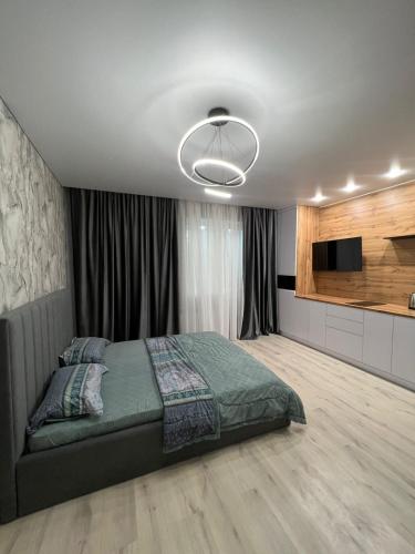 a bedroom with a bed and a flat screen tv at Уральская 45А in Kostanay