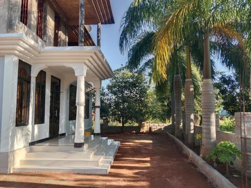 a white house with stairs and a palm tree at Hidalgo Explorers Home in Moshi