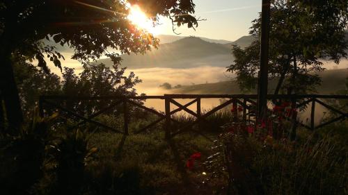 a view of a valley with the sun rising over a field at Ca' le Suore in Cagli